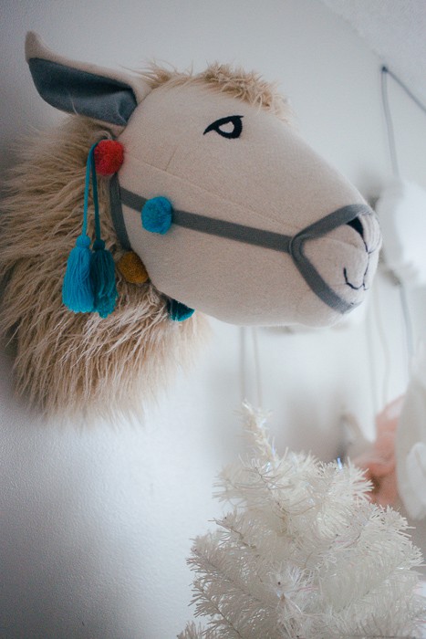 stuffed llama head on grey wall in little girls bedroom